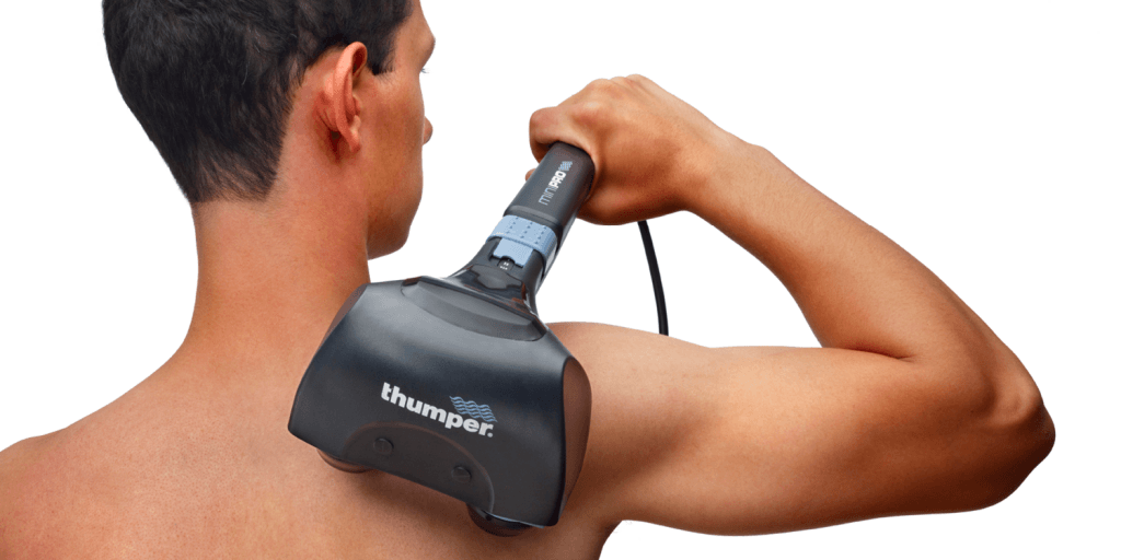 Person using Thumper Mini Pro percussion massager on upper back at home