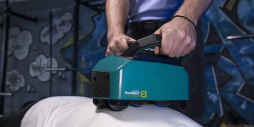 Lithium8 is the first battery-powered Thumper and the only percussive massager of its kind. Model being massaged on his back.